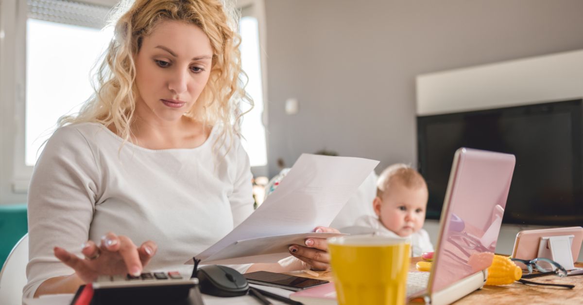 Mutter sitzt mit Baby am Taschenrechner