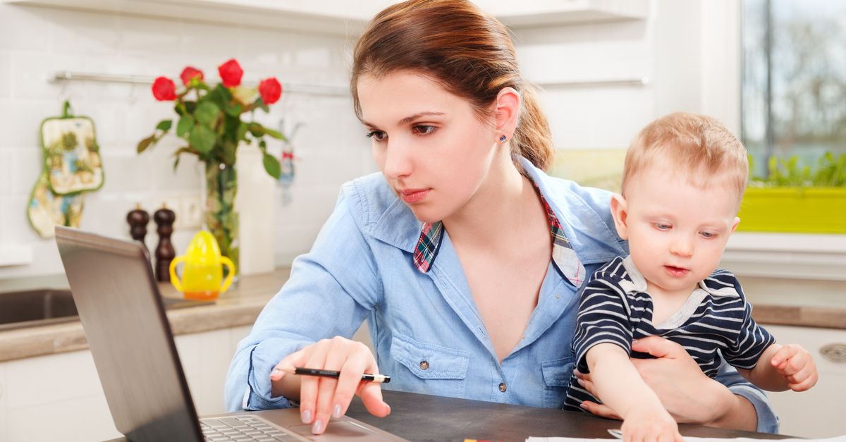 Mutter mit Baby am Schoß beim Lernen