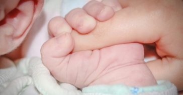 Baby hält Hand